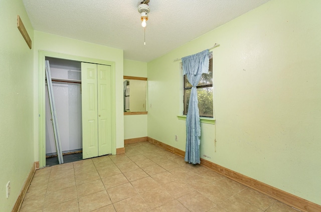 3518 Durango Dr, Dallas, TX 75220 - unfurnished bedroom featuring a closet, a textured ceiling, and light tile patterned flooring
