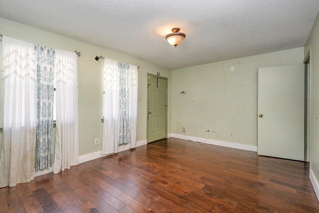 spare room featuring hardwood / wood-style flooring and a textured ceiling