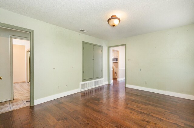 unfurnished room featuring a textured ceiling and hardwood / wood-style flooring