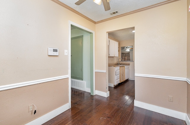 corridor featuring ornamental molding, sink, a textured ceiling, and dark wood-type flooring