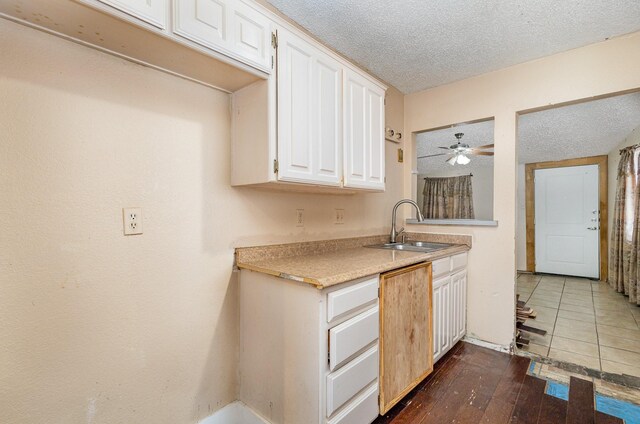 kitchen with ceiling fan, dark hardwood / wood-style flooring, white cabinets, sink, and a textured ceiling