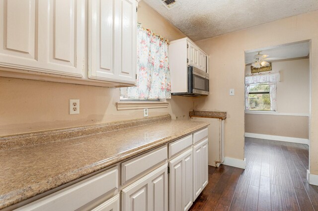 kitchen featuring white cabinets, ceiling fan, dark hardwood / wood-style flooring, and a textured ceiling