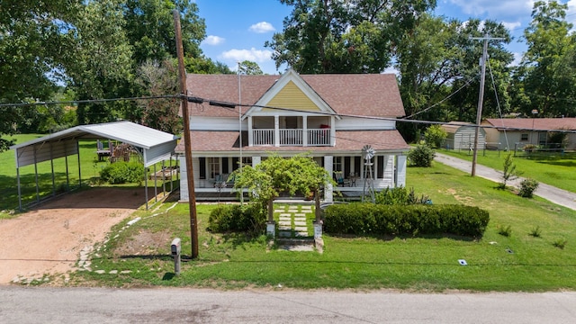 view of front facade with a carport, covered porch, a balcony, and a front yard