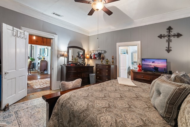 bedroom featuring ornamental molding, ceiling fan, and light hardwood / wood-style flooring