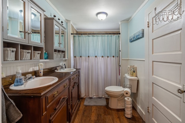 bathroom featuring hardwood / wood-style flooring, a shower with shower curtain, vanity, ornamental molding, and toilet