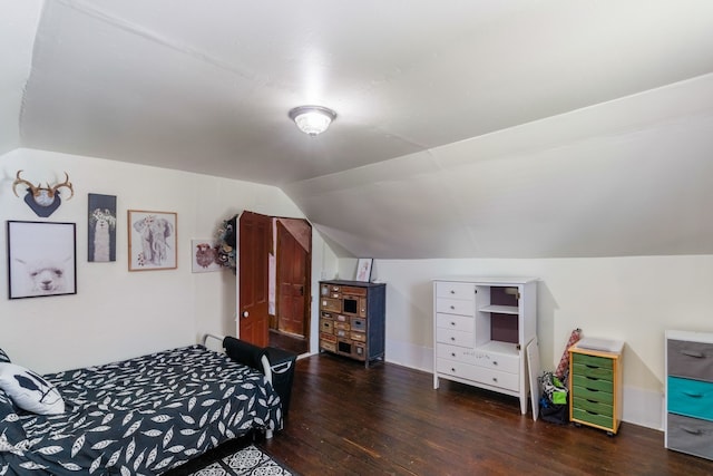 bedroom with dark hardwood / wood-style flooring and vaulted ceiling