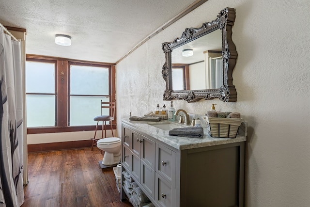 bathroom featuring vanity, hardwood / wood-style floors, a textured ceiling, and toilet