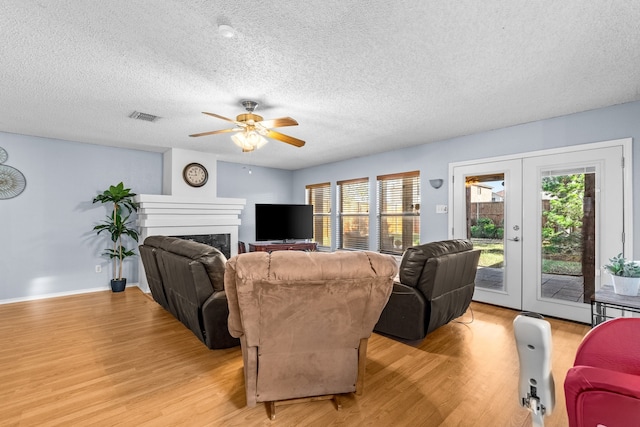 living room with french doors, light hardwood / wood-style floors, and plenty of natural light