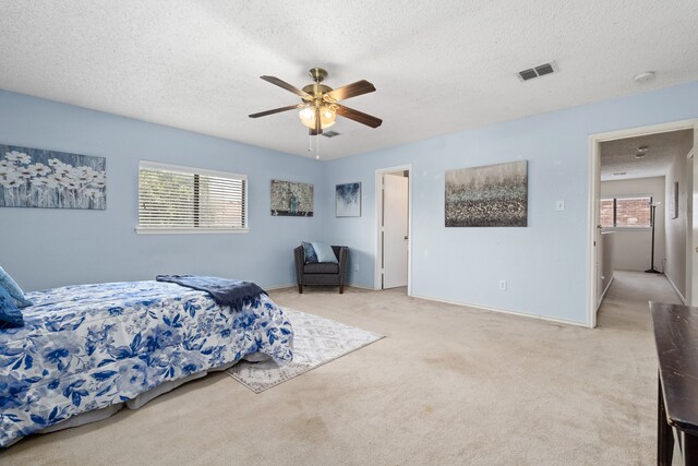 carpeted bedroom with a textured ceiling and ceiling fan