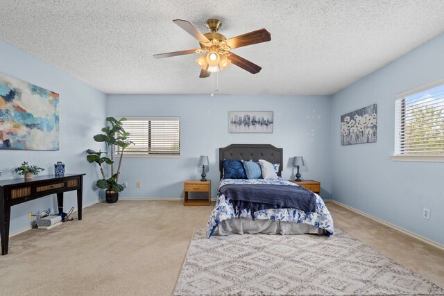 carpeted bedroom with a textured ceiling, ceiling fan, and multiple windows