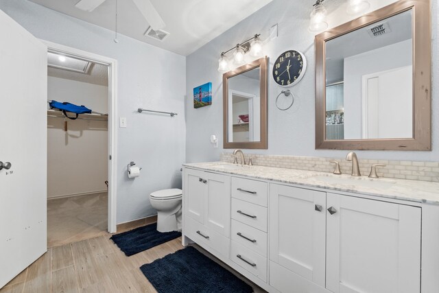 bathroom featuring toilet, vanity, decorative backsplash, and hardwood / wood-style flooring