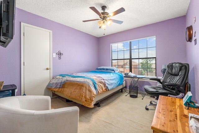 bedroom featuring ceiling fan, carpet floors, and a textured ceiling