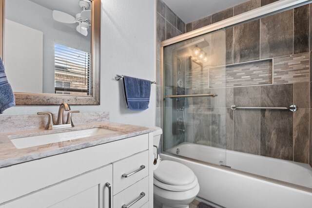 full bathroom with toilet, enclosed tub / shower combo, ceiling fan, and vanity