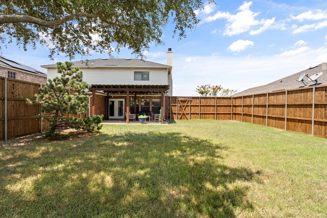 back of house featuring a lawn, french doors, and a patio area