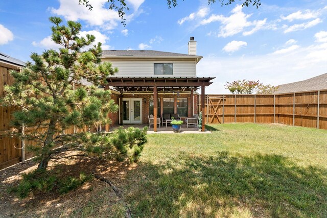 back of property featuring french doors, a patio area, and a yard