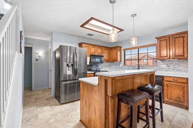 kitchen with a textured ceiling, backsplash, a center island, and black appliances