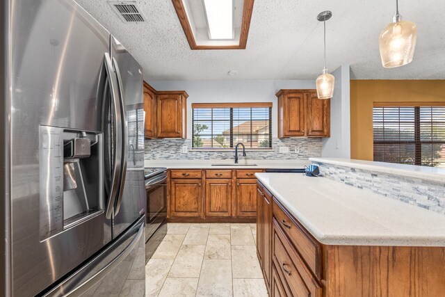 kitchen featuring backsplash, pendant lighting, stainless steel refrigerator with ice dispenser, sink, and range with electric cooktop