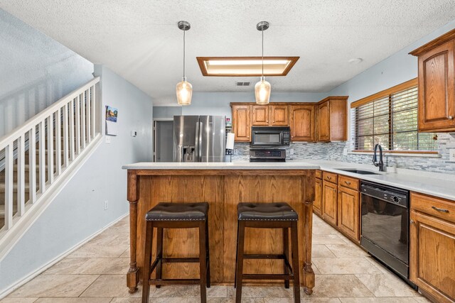 kitchen with black appliances, backsplash, sink, and a kitchen island