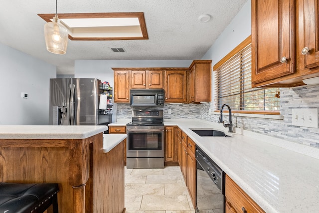 kitchen featuring tasteful backsplash, black appliances, sink, hanging light fixtures, and a textured ceiling