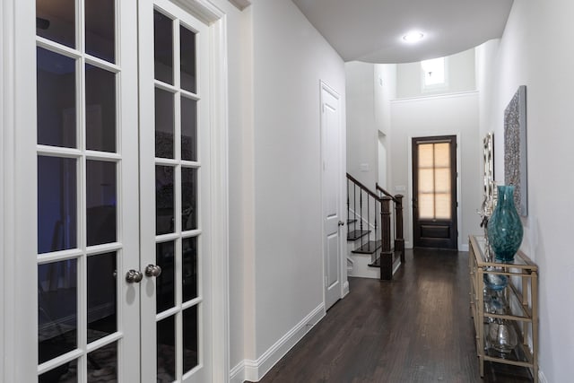 entryway featuring dark hardwood / wood-style flooring, a towering ceiling, and french doors