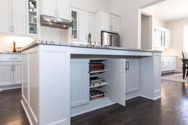 kitchen with backsplash, high end refrigerator, light stone countertops, and white cabinets