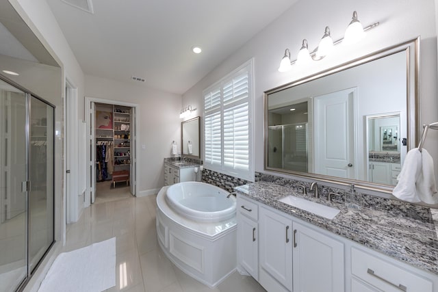 bathroom with tile patterned flooring, shower with separate bathtub, and vanity