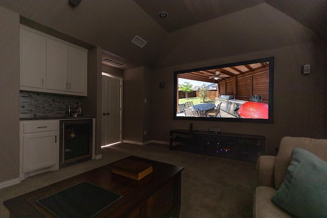 home theater room with vaulted ceiling, carpet flooring, bar area, and wine cooler