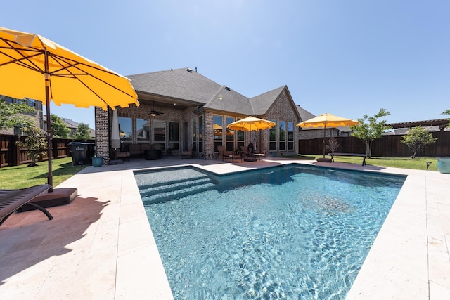 view of swimming pool featuring ceiling fan and a patio