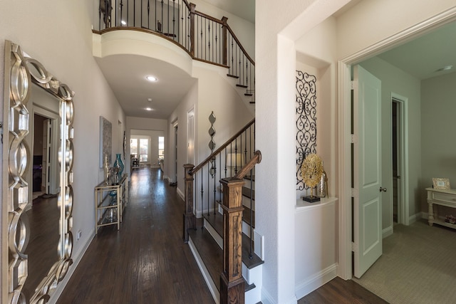 entrance foyer with dark hardwood / wood-style floors and a towering ceiling