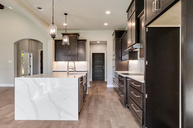 4836 S Theresa, Denison, TX 75020 - kitchen featuring tasteful backsplash, visible vents, arched walkways, recessed lighting, and light wood finished floors