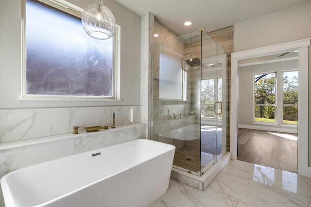 bathroom featuring wood-type flooring and separate shower and tub