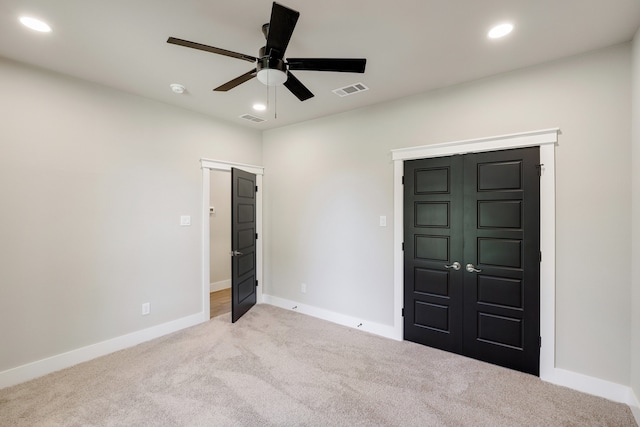 unfurnished bedroom with light colored carpet, a closet, and ceiling fan