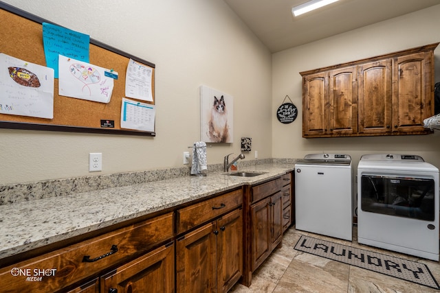 clothes washing area with sink, independent washer and dryer, cabinets, and light tile patterned floors