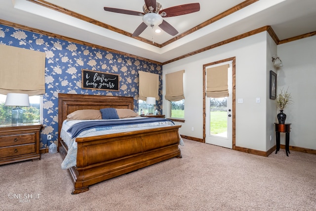 carpeted bedroom featuring a tray ceiling, ceiling fan, and ornamental molding