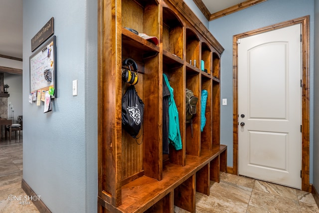 mudroom featuring light tile patterned flooring and crown molding