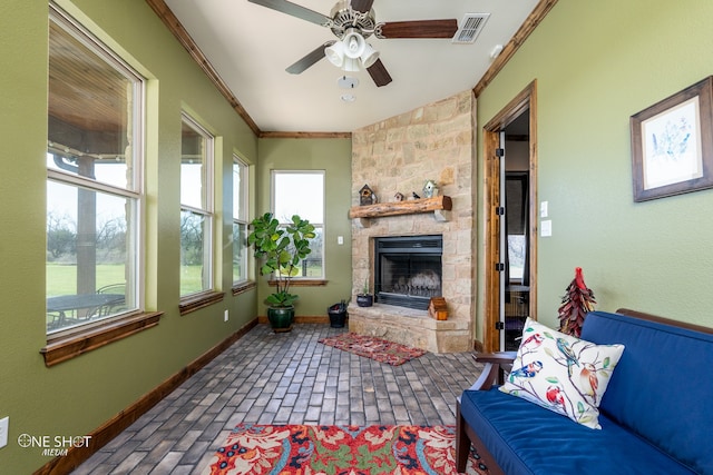 living room with a fireplace, ornamental molding, and ceiling fan