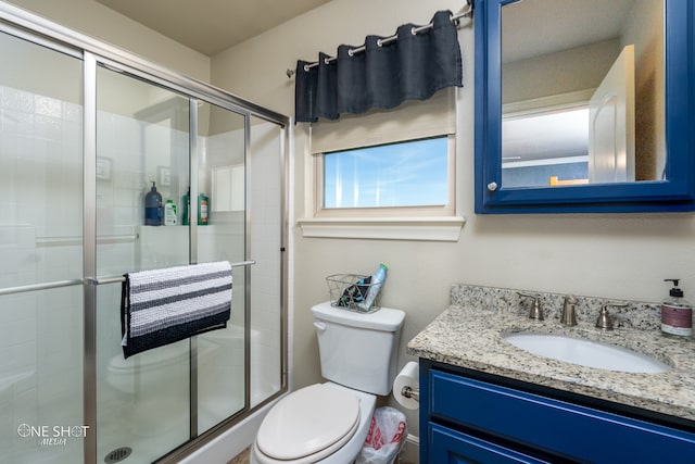 bathroom with toilet, vanity, and an enclosed shower