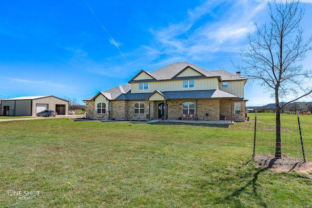 view of front of home with a garage, a front lawn, and an outdoor structure