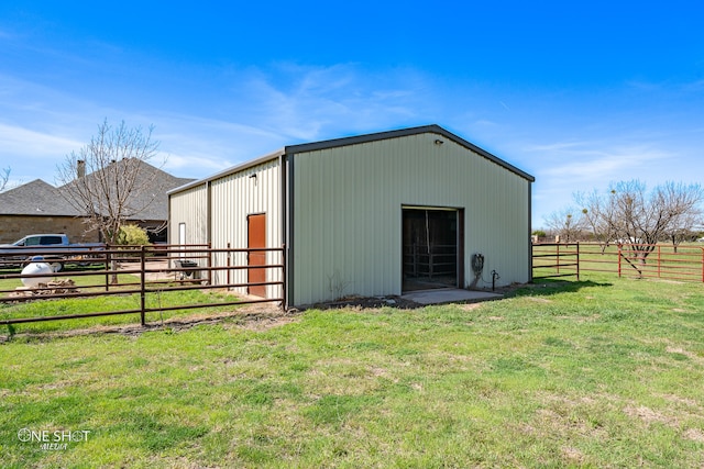 view of outbuilding featuring a rural view and a yard