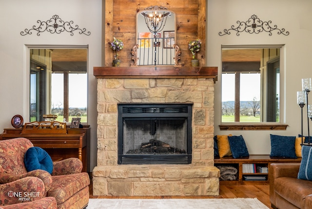 living room featuring hardwood / wood-style flooring, a notable chandelier, and a fireplace