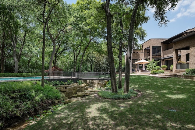 view of property's community featuring a pool and a yard