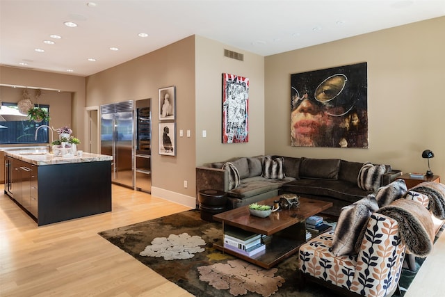 living room with sink and light hardwood / wood-style flooring