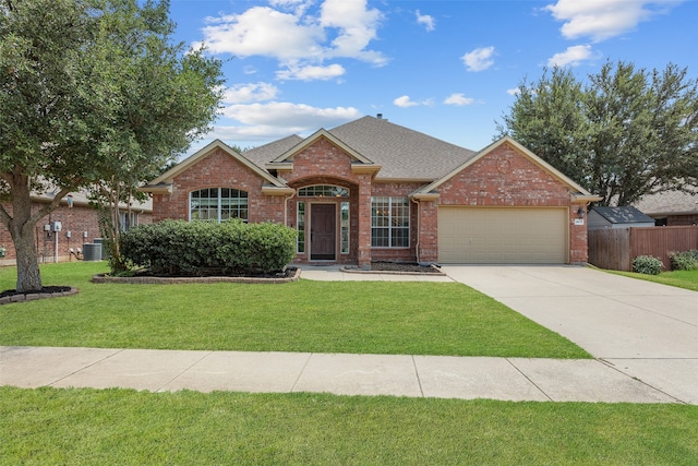 single story home featuring cooling unit, a garage, and a front yard