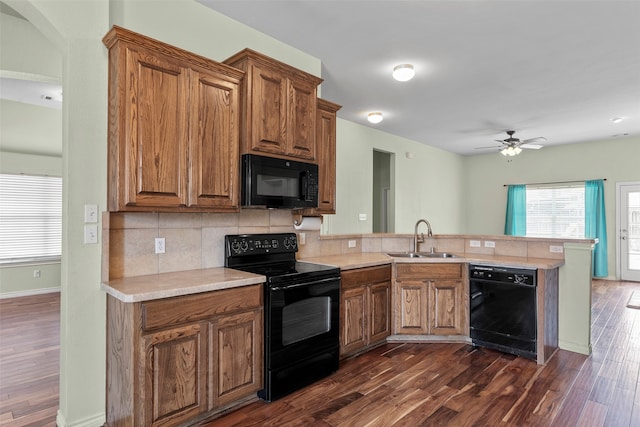 kitchen featuring black appliances, sink, kitchen peninsula, backsplash, and ceiling fan