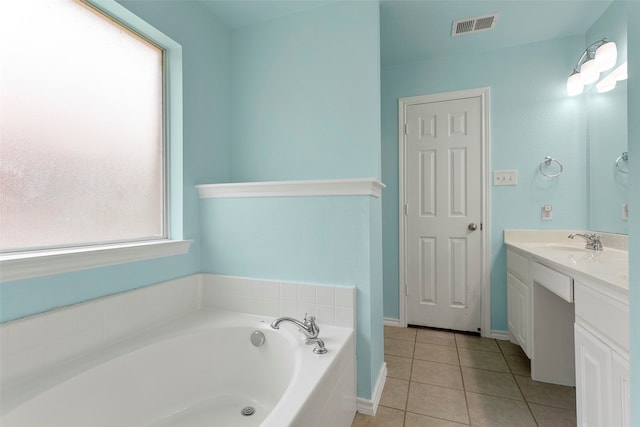 bathroom featuring vanity, tile patterned floors, and tiled bath