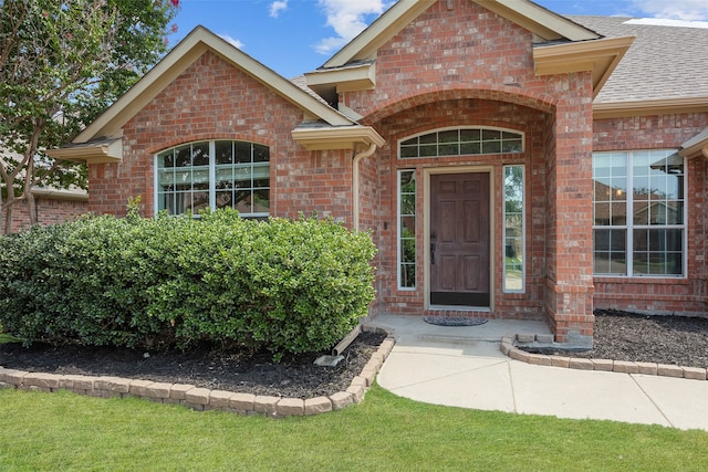 view of exterior entry with a lawn