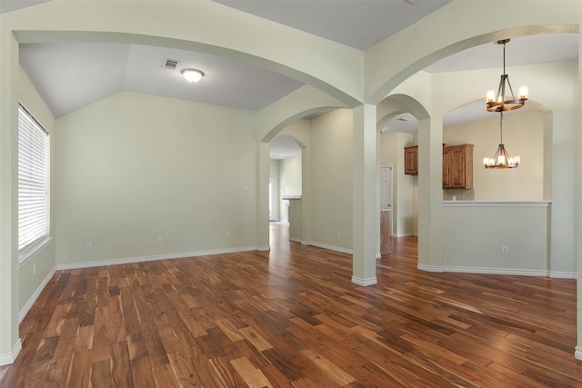 spare room featuring hardwood / wood-style flooring, lofted ceiling, a wealth of natural light, and a chandelier