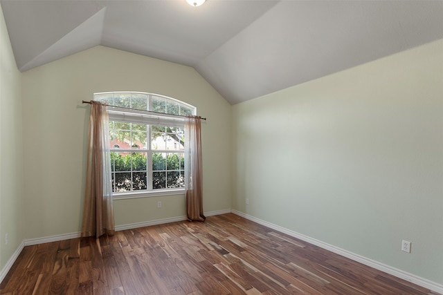 empty room with hardwood / wood-style flooring and vaulted ceiling