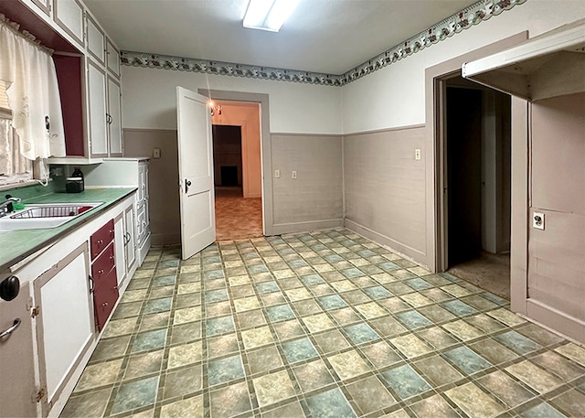 kitchen with sink, white cabinets, and light tile patterned floors