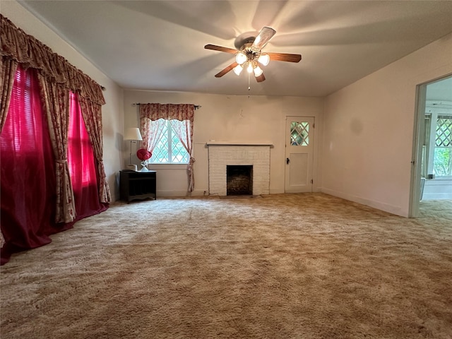 unfurnished living room featuring carpet, a wealth of natural light, and a brick fireplace